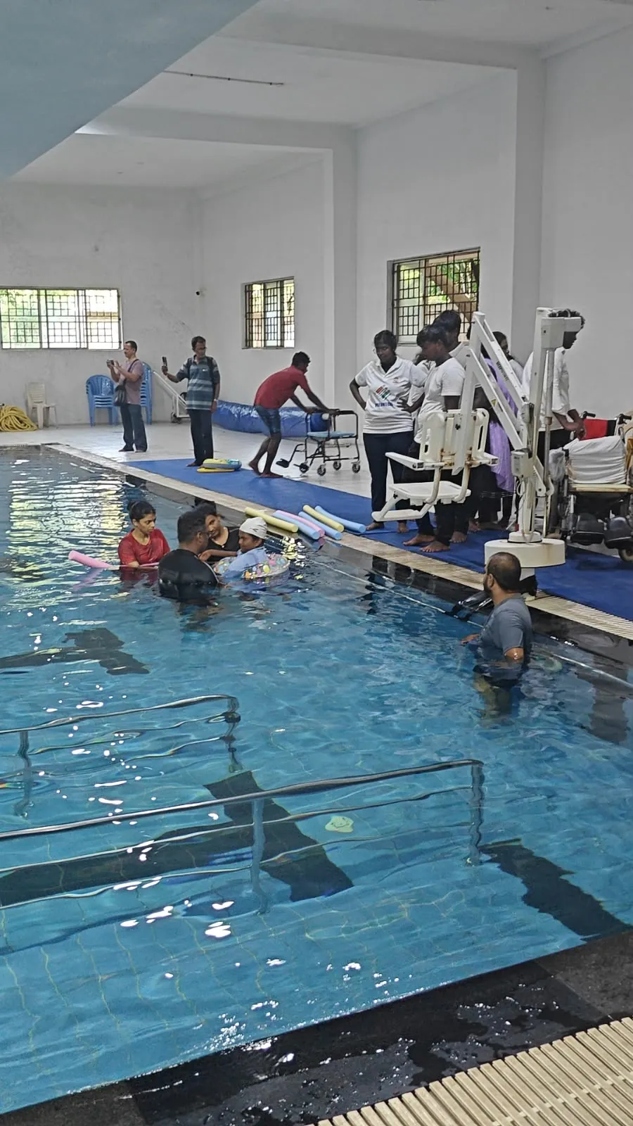 A member being lowered into the pool with a hoist during a hydrotherapy session