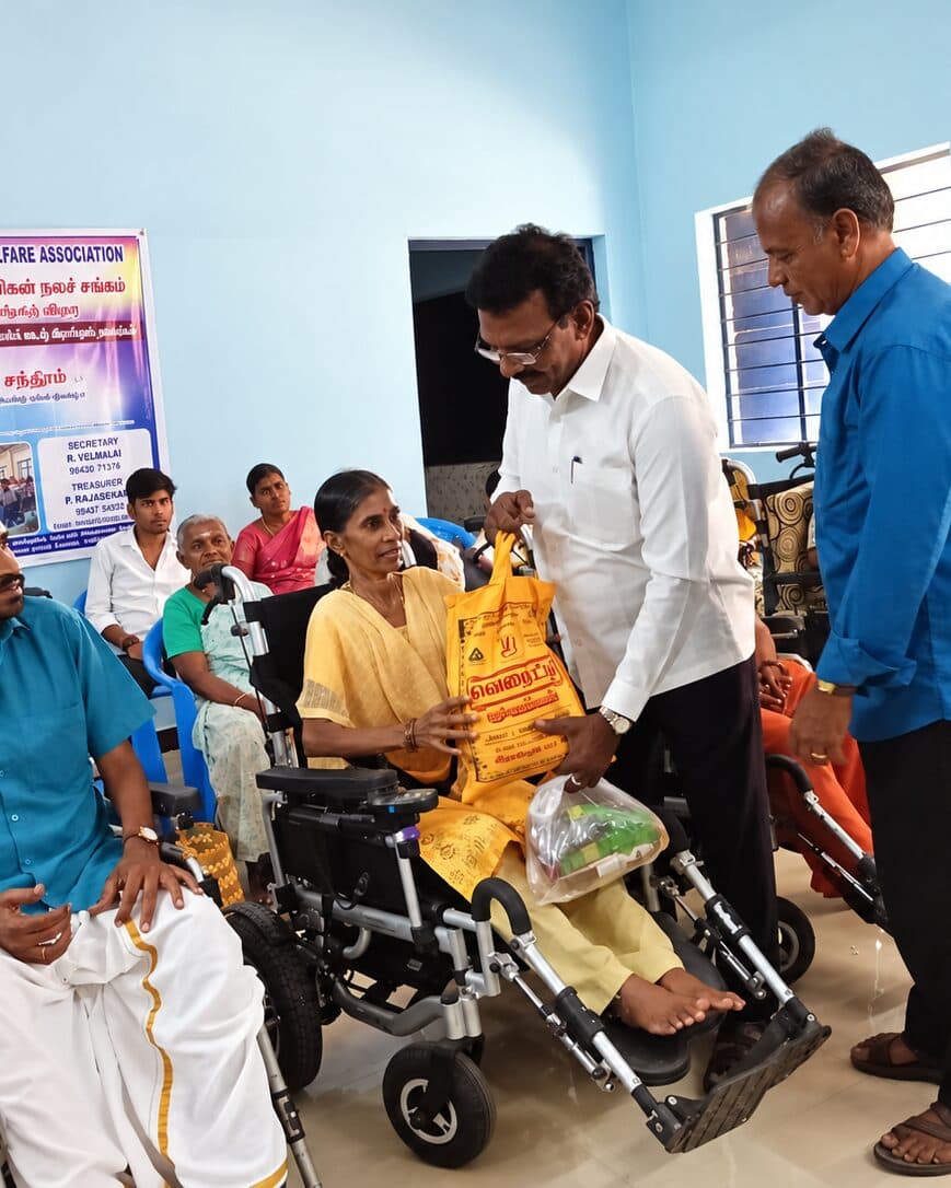 A woman receiving a bag of provisions during a TNMDA distribution meeting