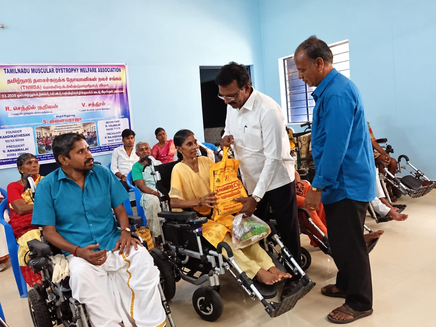 Volunteers distributing provisions to a member in a wheelchair