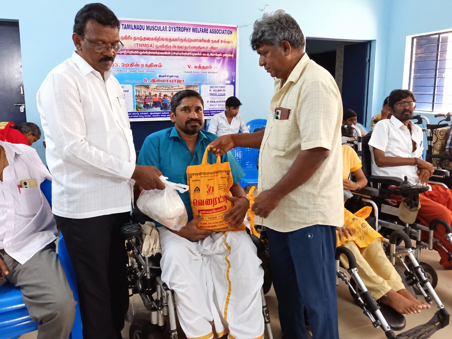 A TNMDA volunteer handing provisions to a member during a community event
